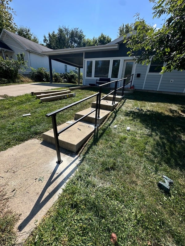 Metal railing installation alongside sidewalk